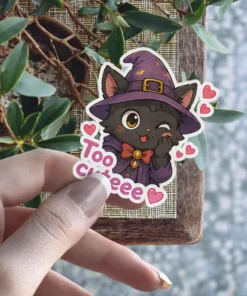 A winking black cat wearing a witch hat and cape, with the words 'Too cuteee' and hearts, as a vinyl sticker.