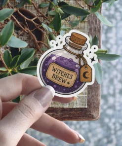 A cartoon-style glass bottle filled with bubbling purple potion, cork stopper, and a tag labeled 'WITCHES BREW' with a crescent moon, surrounded by sparkle accents, vinyl sticker.